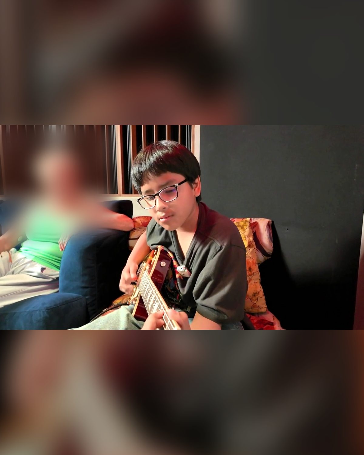 Alex playing his new guitar in a studio